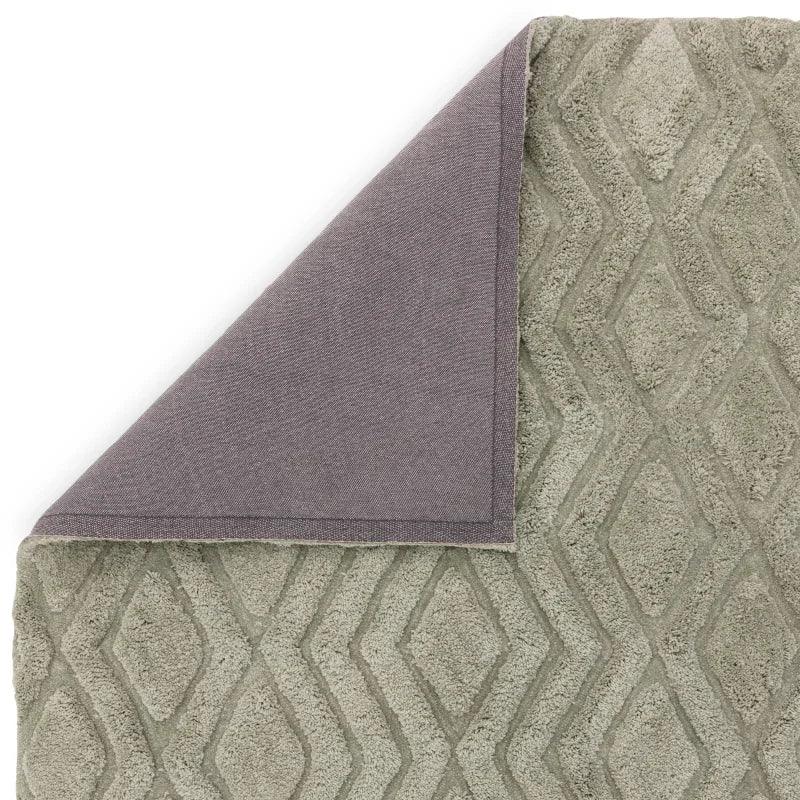 Grey patterned bath mat with diamond design and corner folded to show backing