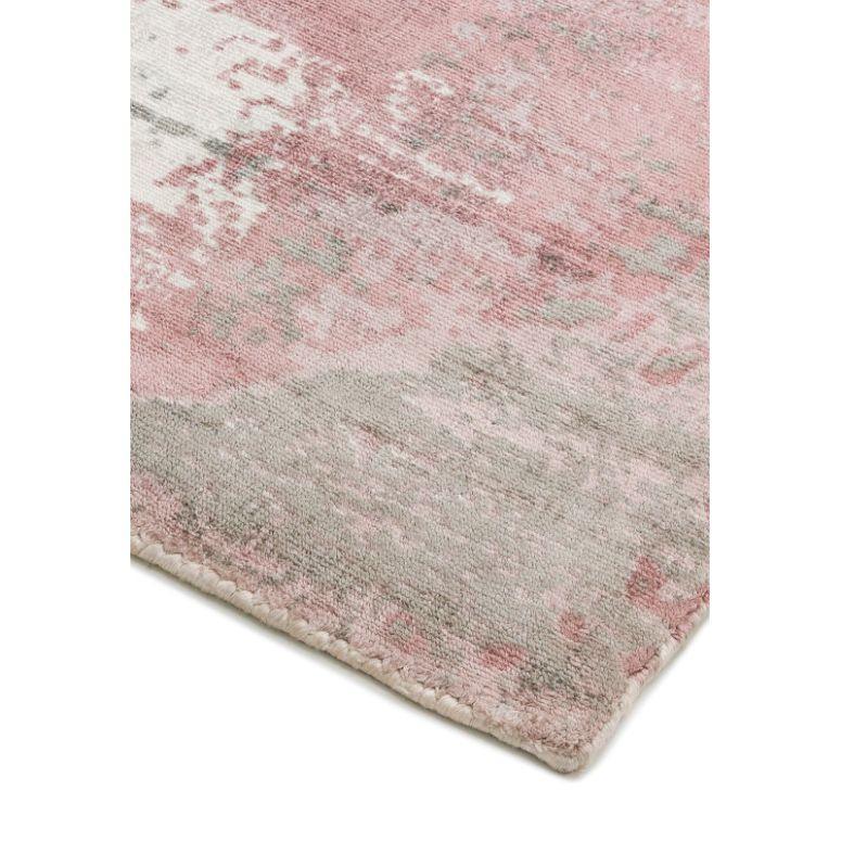 Close-up of pink and grey patterned rug corner with soft textured surface