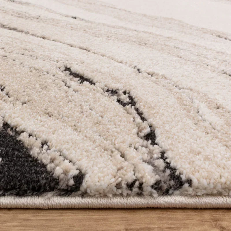 Close view modern cream shaggy rug with black and beige abstract pattern on wood floor