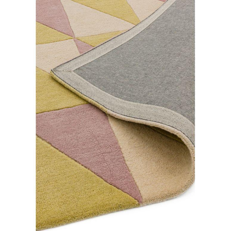 Geometric wool rug with yellow, pink, and beige triangles, close-up of corner detail