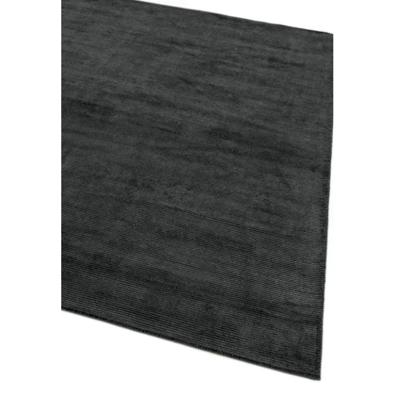 Charcoal grey area rug with fine textured pattern, shown from an angled top view