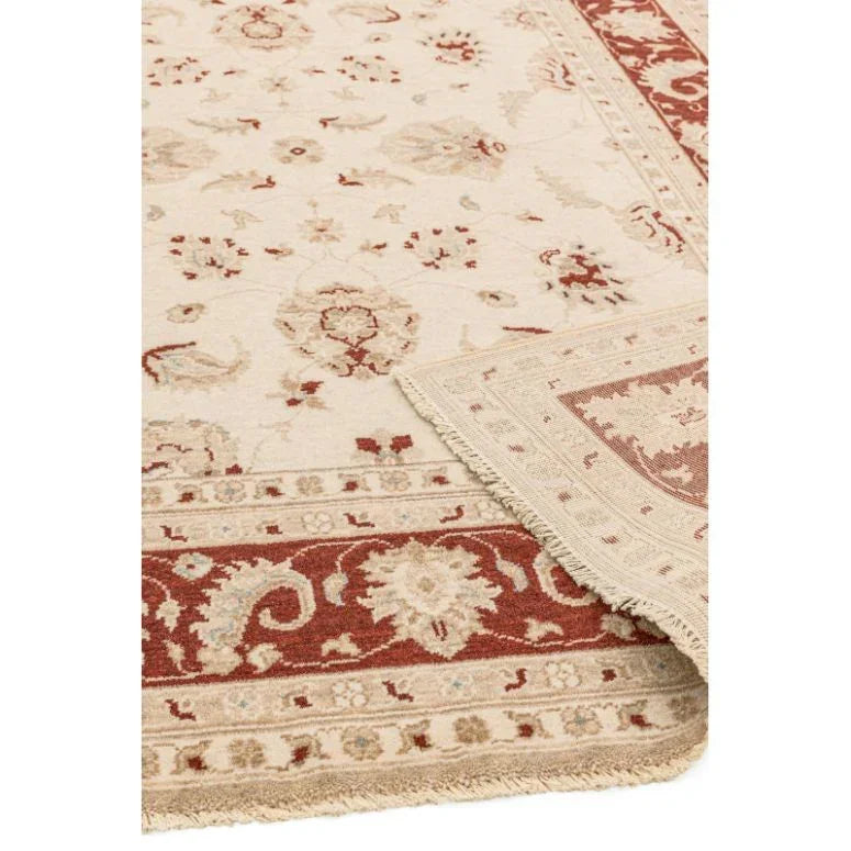 Cream and red floral area rug with decorative border and fringed edges
