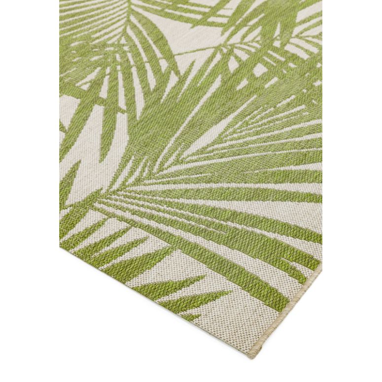 Green palm leaf patterned rug with beige background, close-up of woven texture