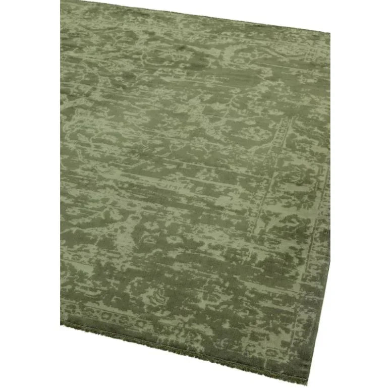 Green patterned rug with subtle distressed texture and finished edging