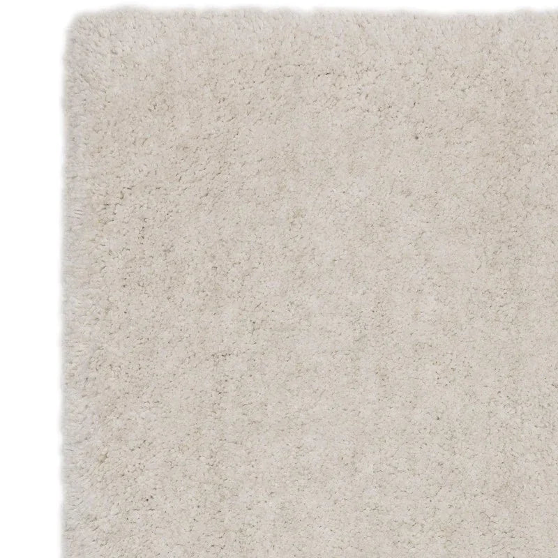 Closeup of cream shaggy rug texture with plush pile