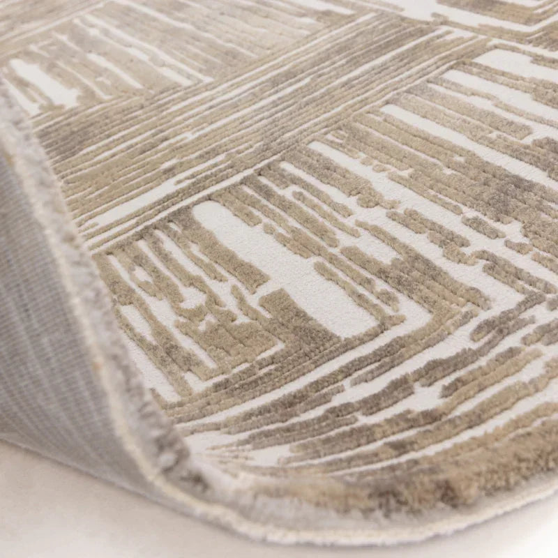 Beige and cream patterned rug corner showing textured pile and underside detail