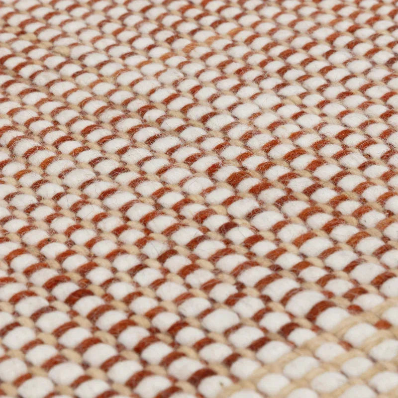 Closeup of textured wool rug with beige and brown woven pattern