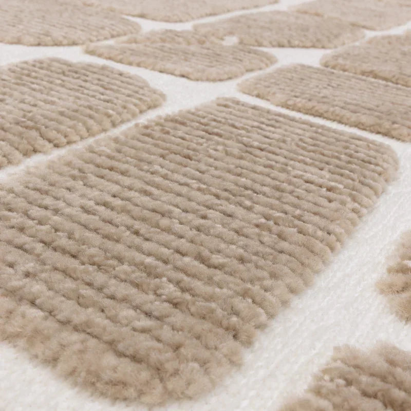 Close up of beige textured rug with raised geometric pattern on white background