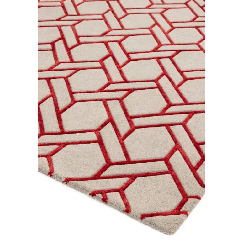 Beige area rug with geometric red pattern and soft textured surface, corner angle view