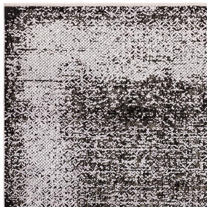 Black and white patterned rug with intricate geometric and faded distressed design