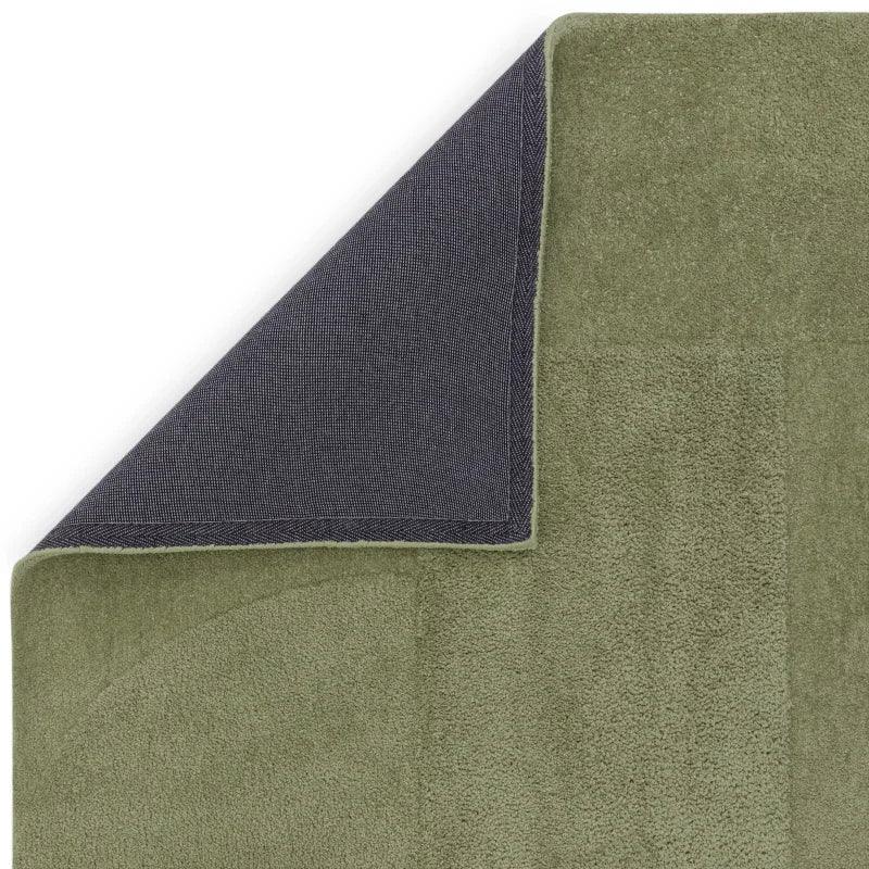 Olive green bath mat with textured cotton surface and non-slip dark backing corner detail