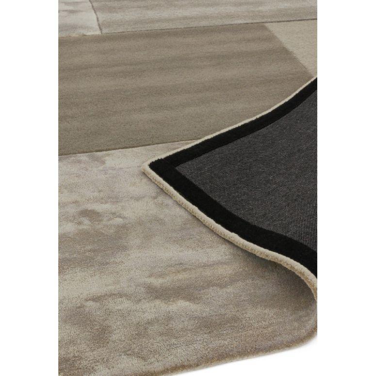 Beige and taupe area rug with geometric pattern and black edged underside visible