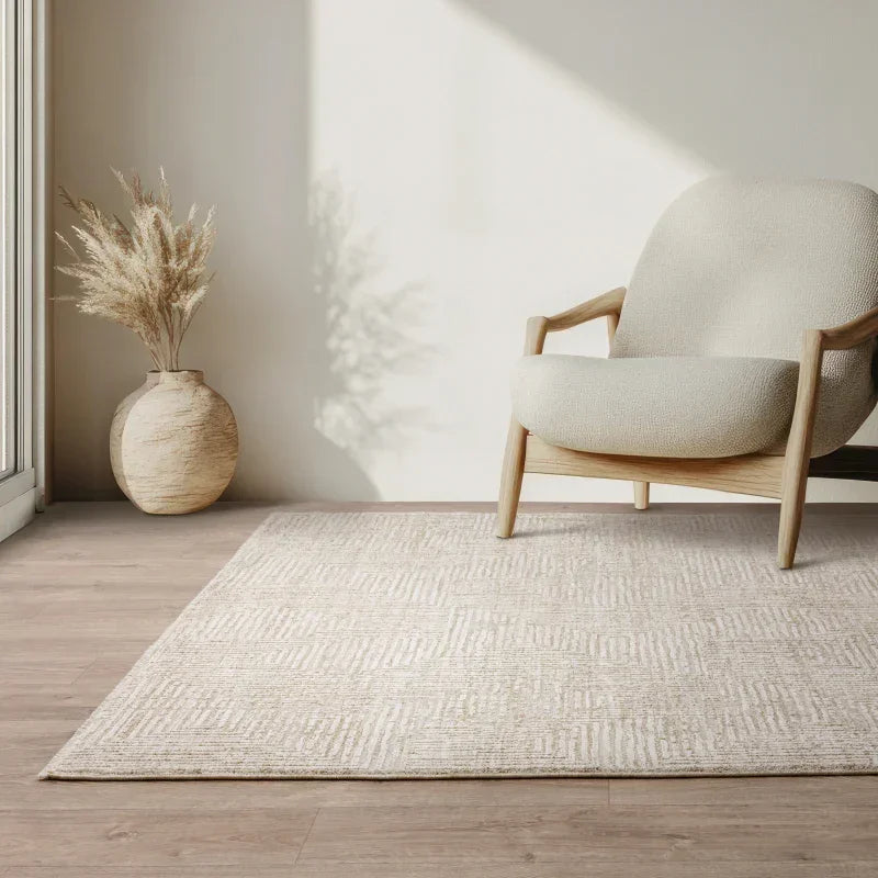 Textured cream area rug on wooden floor with modern armchair and decorative vase