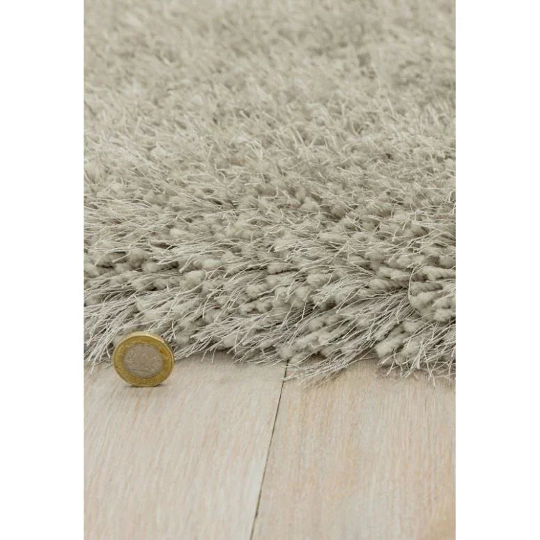 Beige shaggy rug close-up showing high pile texture on light wood floor
