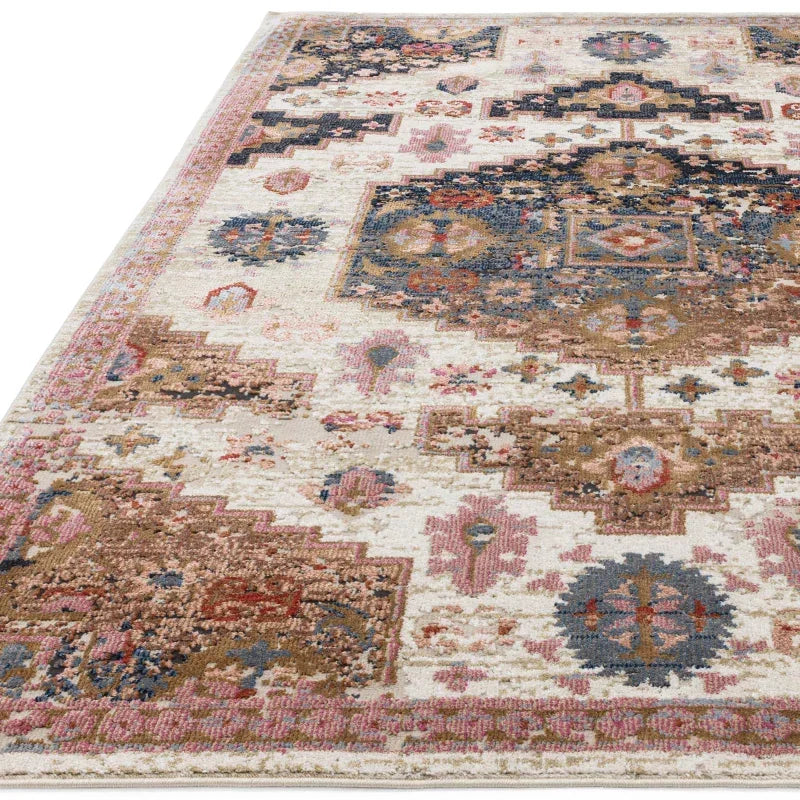 Patterned area rug with pink, blue, and beige geometric designs on a cream background