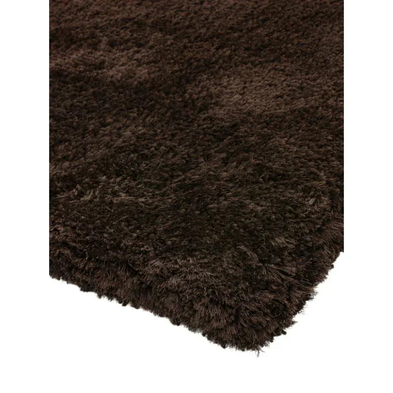 Dark brown shaggy rug close-up showing thick, soft pile and rectangular edge
