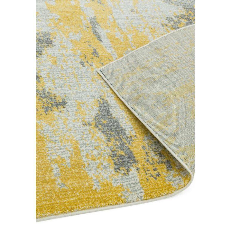 Modern area rug with yellow and grey abstract pattern, corner flipped to show backing