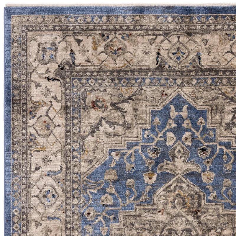 Blue and grey patterned area rug with ornate floral and geometric border design