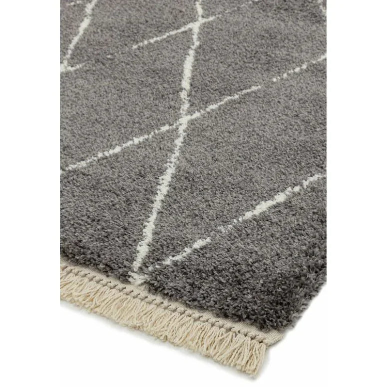 Grey shaggy rug with white diamond pattern and beige fringe edge