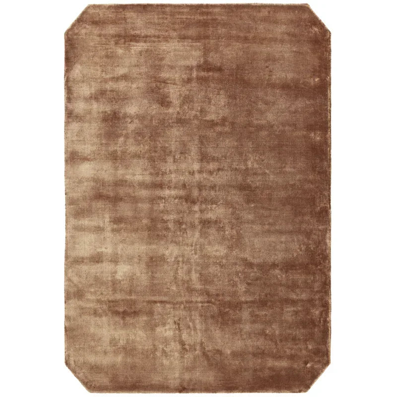 Brown rectangular area rug with cut corners and plush texture