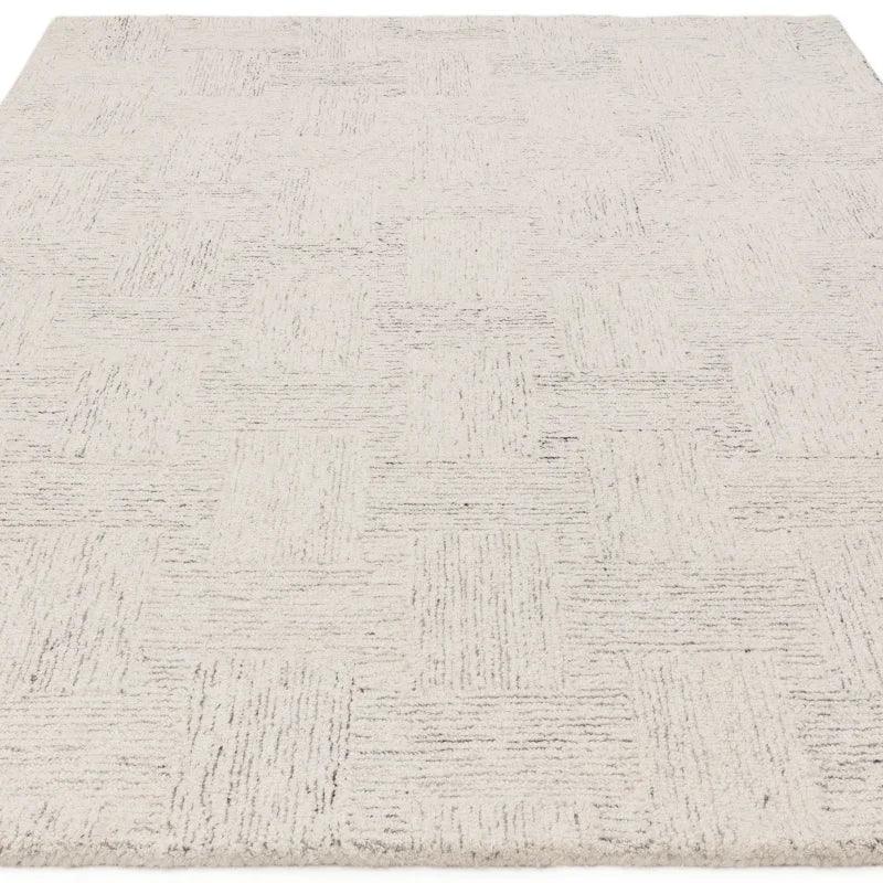 Cream textured area rug with geometric pattern and soft pile, shown from corner angle