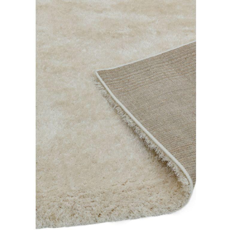 Soft cream shaggy rug with corner folded to show non-slip backing detail