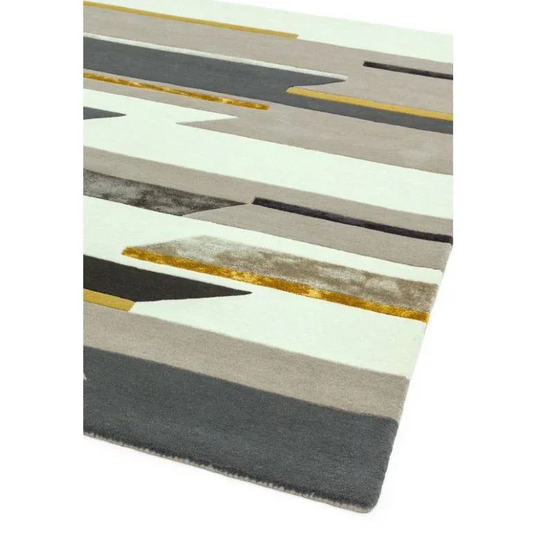 Geometric area rug with grey, beige, black and gold stripes on a light background