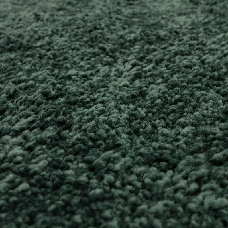 Close view of textured green rug pile with soft, plush carpet surface