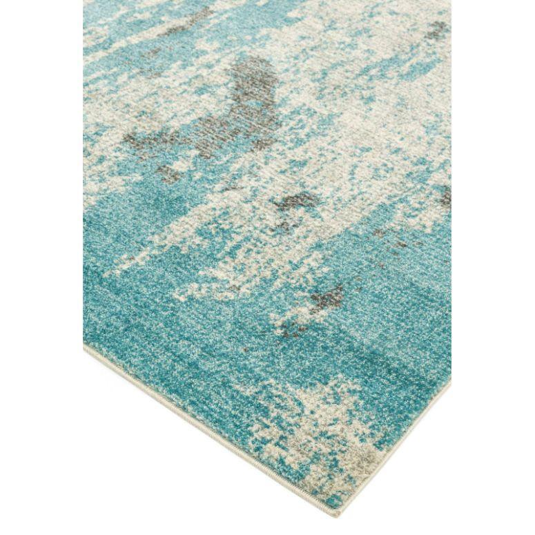Blue and cream abstract area rug corner with textured pattern