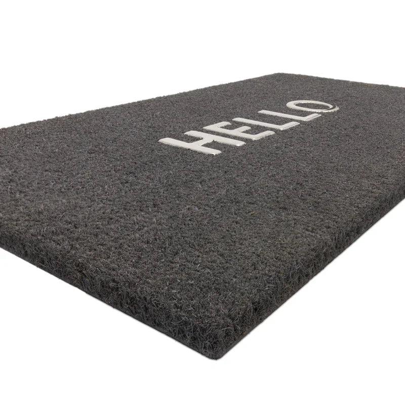 Grey doormat with HELLO text in white, close side angle view highlighting textured surface