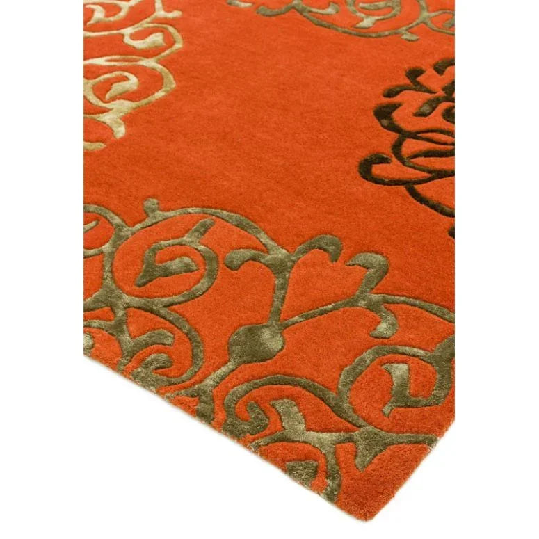 Red area rug with olive green scroll pattern detail on corner
