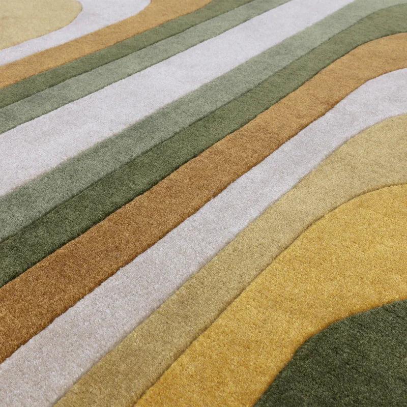 Geometric patterned area rug with raised green, beige, and gold stripes, close-up view