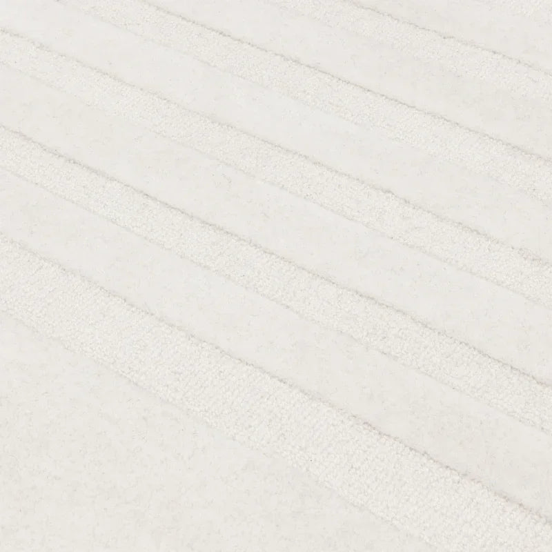 Close up of cream textured rug with linear pattern and soft pile