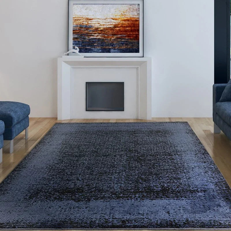 Blue living room rug on wooden floor with modern sofas and abstract art above fireplace