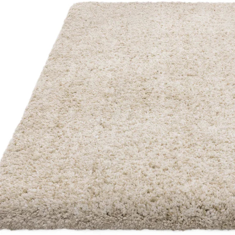 Cream shaggy rug with thick pile texture shown from a side angle