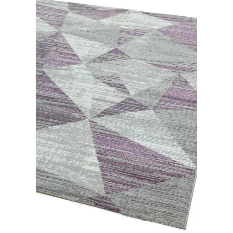 Purple and grey geometric area rug with abstract triangular pattern, close-up of corner