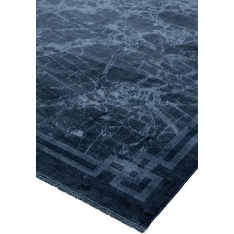 Navy blue area rug with geometric border and marble pattern detail