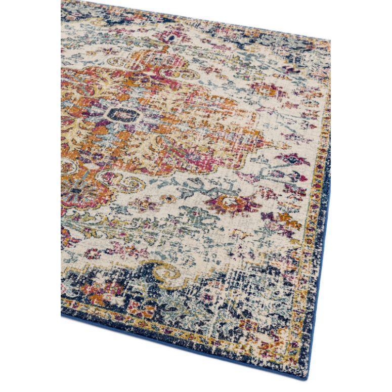Multicoloured vintage patterned rug with distressed finish and blue border on white background