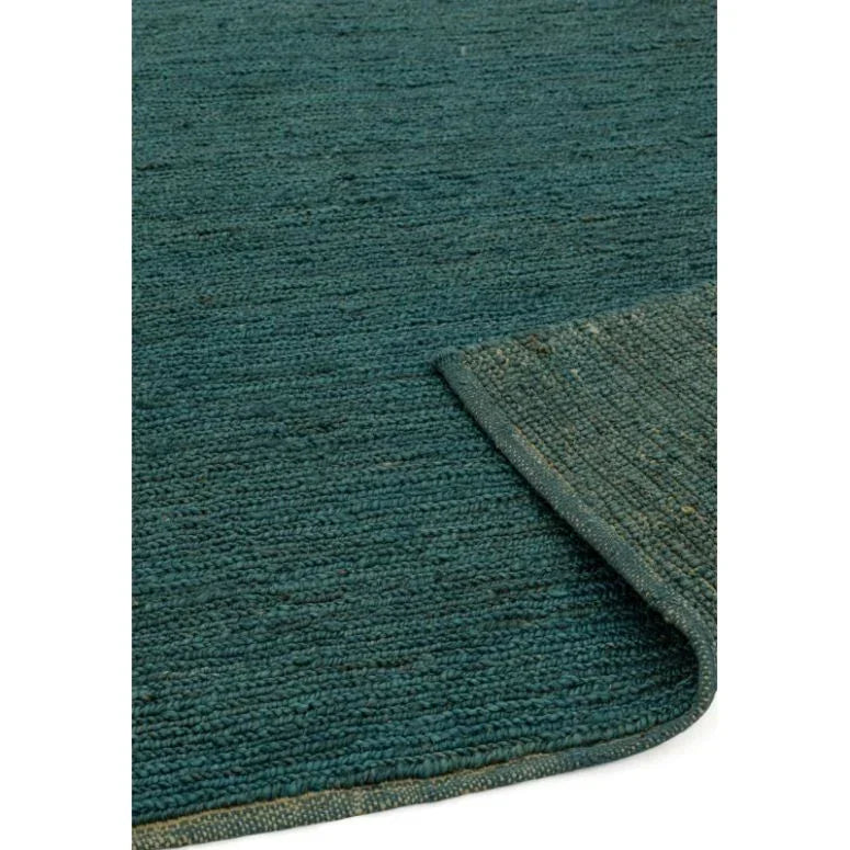 Textured teal area rug with visible woven detail and corner turned up