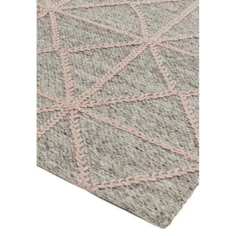 Grey wool rug with pink geometric stitched pattern, closeup corner view