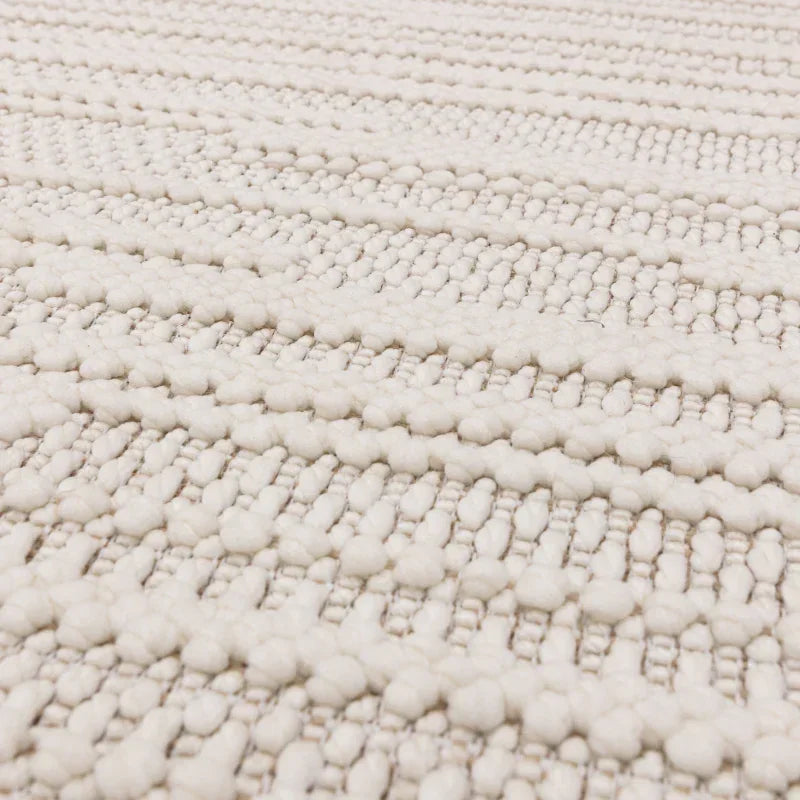 Textured cream wool rug close-up showing woven stripes and raised loop detail