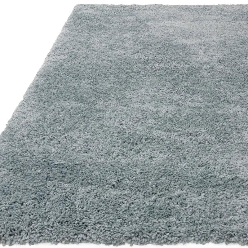Soft grey shaggy rug with thick pile texture viewed from an angle