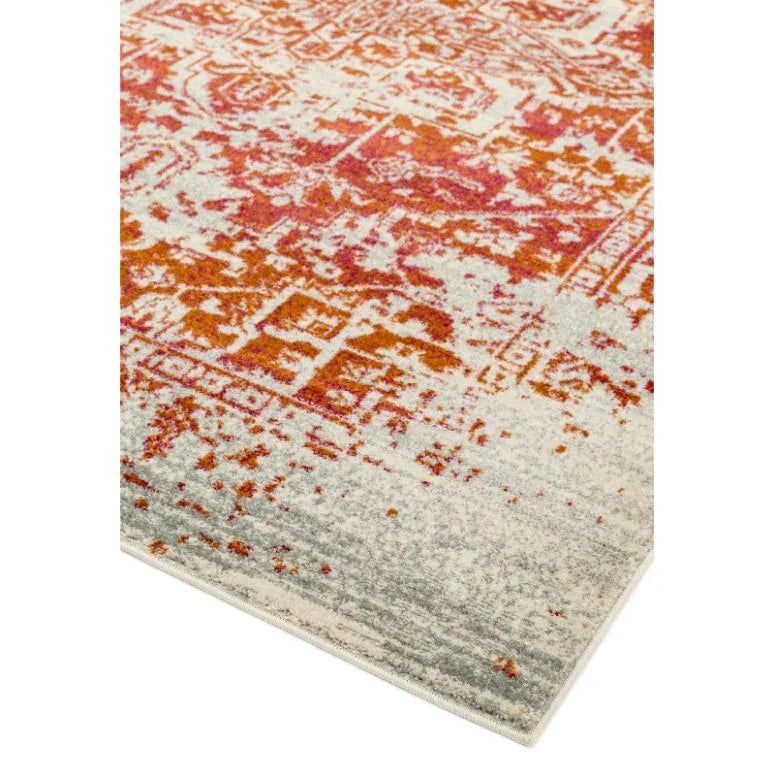 Red and orange patterned rug with faded design and grey edges, corner view