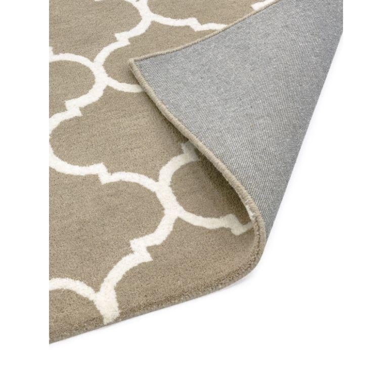 Beige patterned rug with white geometric design and visible grey backing corner