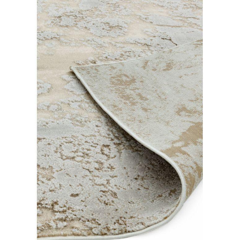 Beige and cream abstract area rug with corner flipped to show backing texture