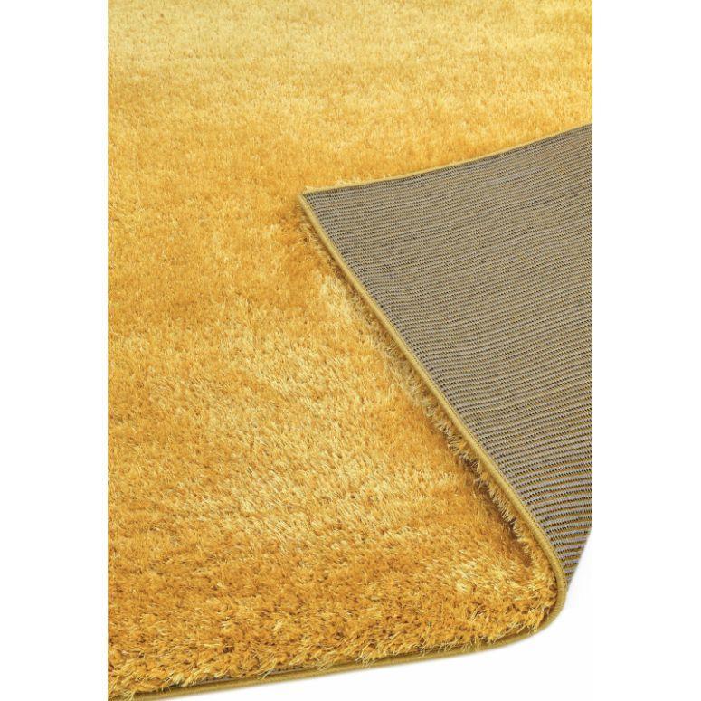 Yellow shaggy rug with corner flipped to show backing detail