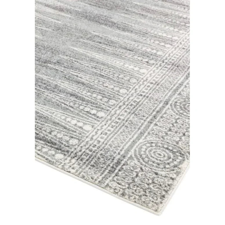 Grey patterned area rug with textured geometric border design, angled corner view