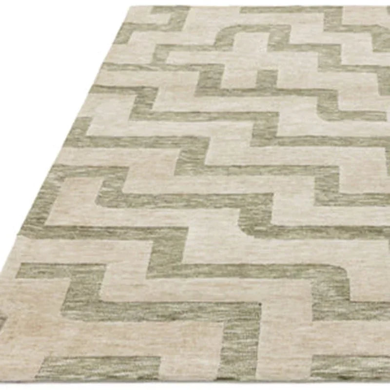 Beige and green geometric patterned rug with rectangular shapes, viewed from an angle