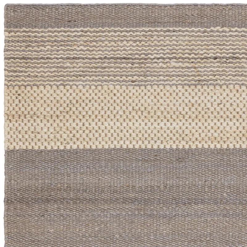 closeup of woven wool rug with beige and grey stripes and textured pattern