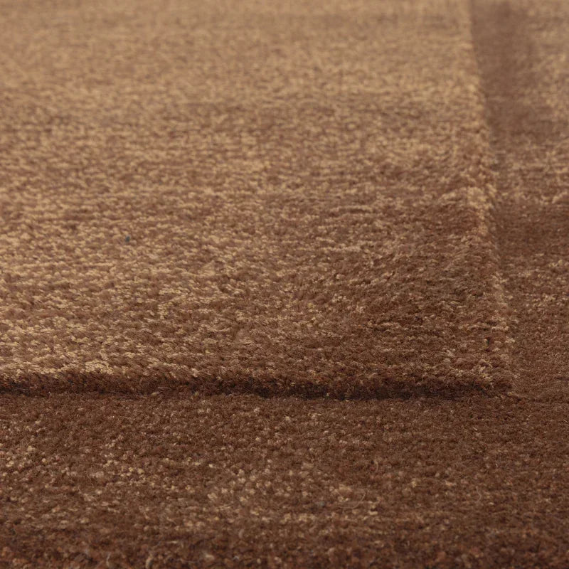 Close-up of brown textured area rug with raised geometric pattern